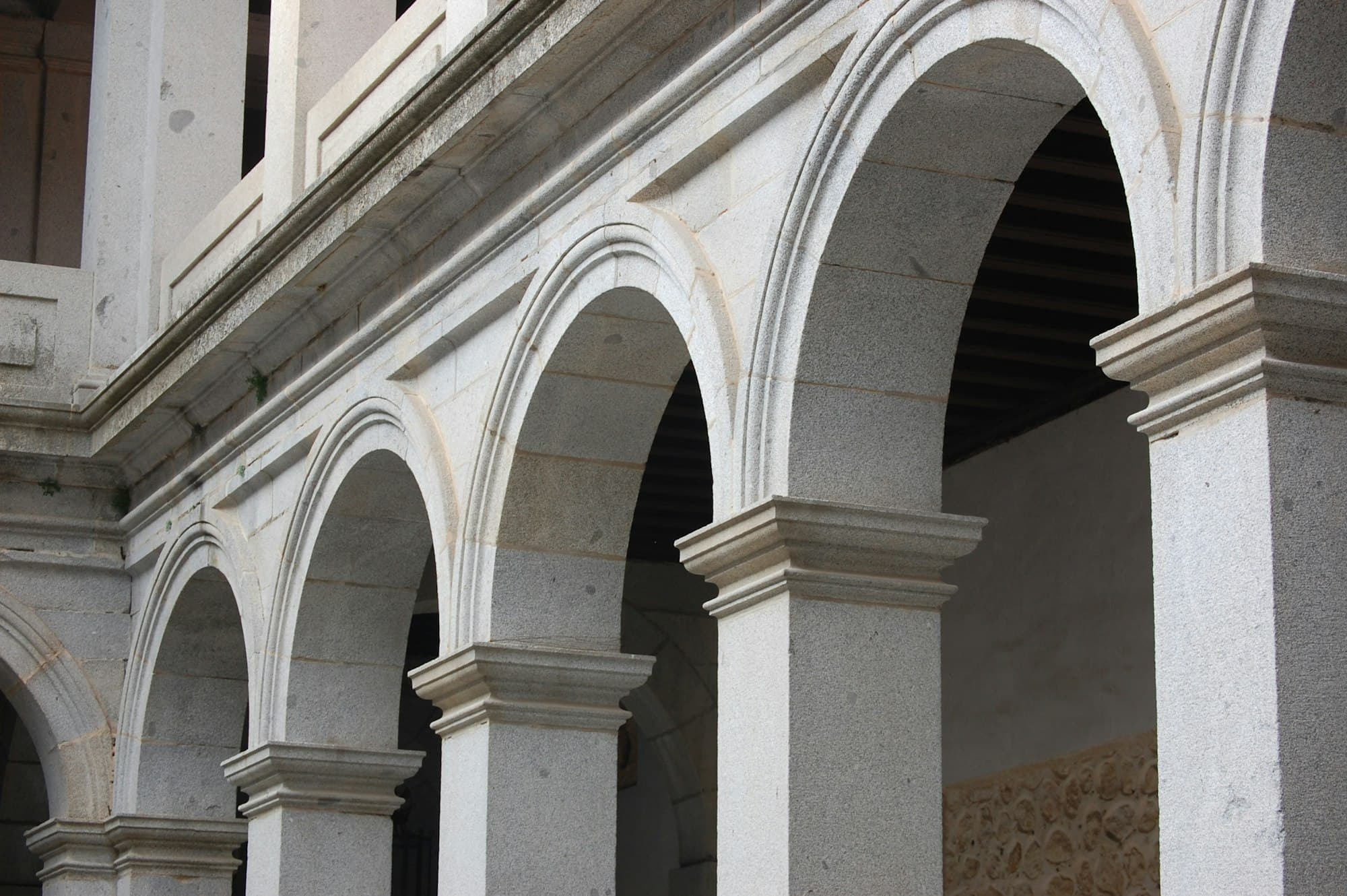 Sunlit carved stone arches in a colonnade