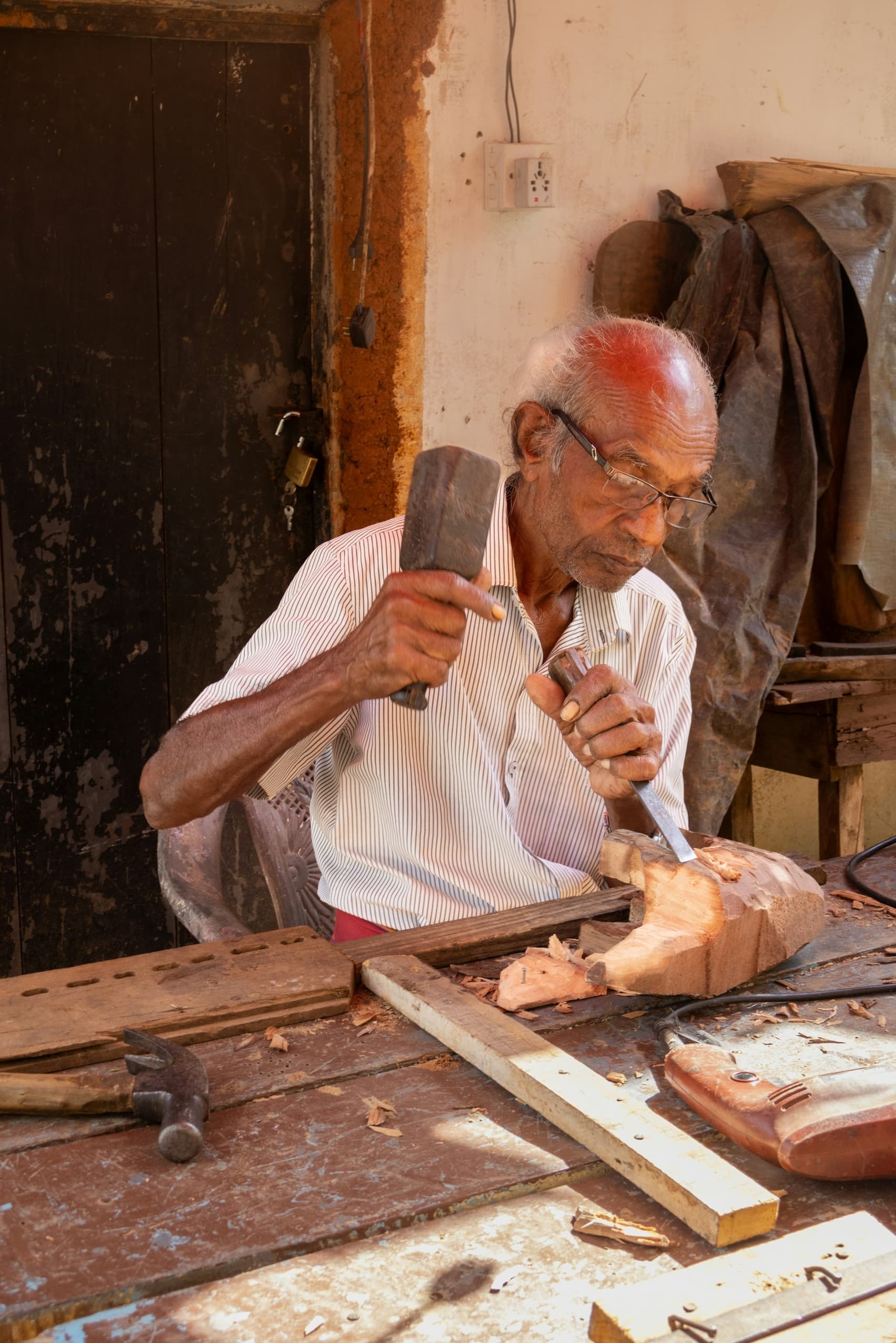 Master carver finishing lettering by hand