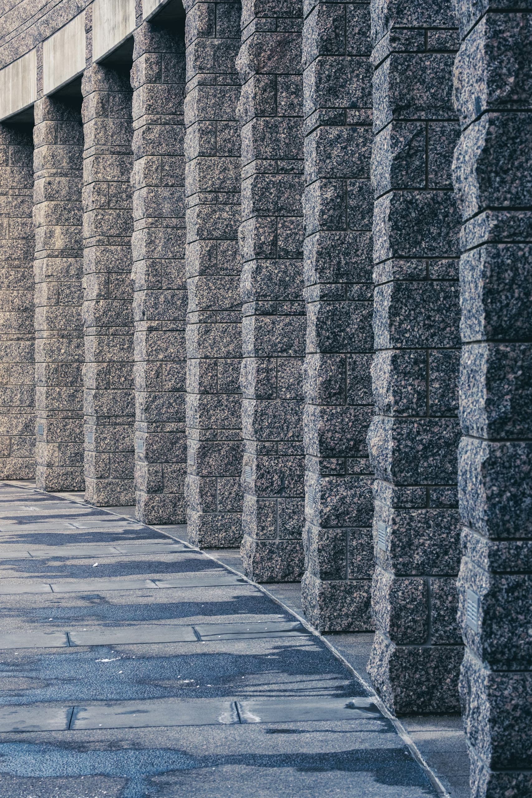 Row of split-face granite columns along a walkway