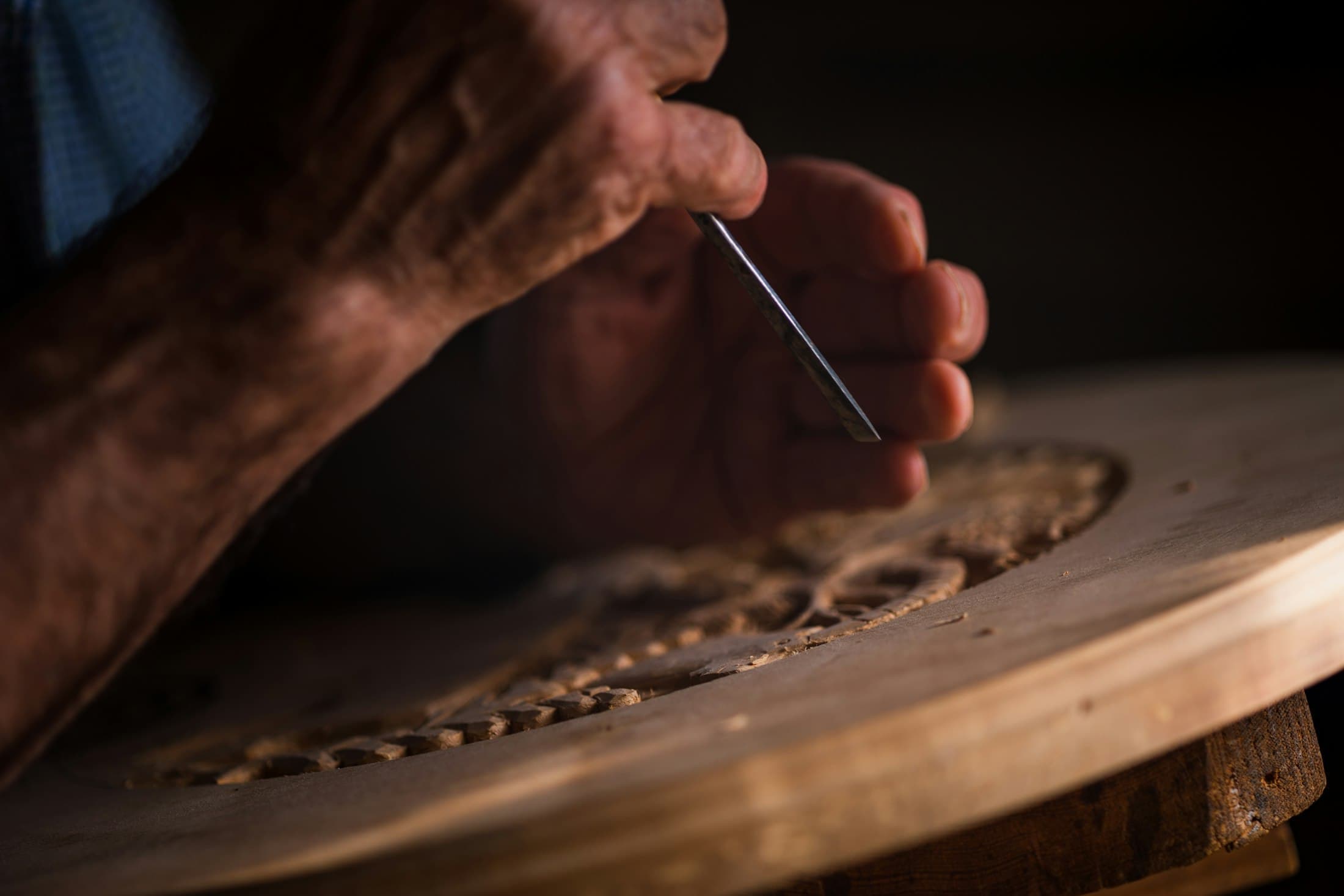Artisan hand-finishing a carved surface